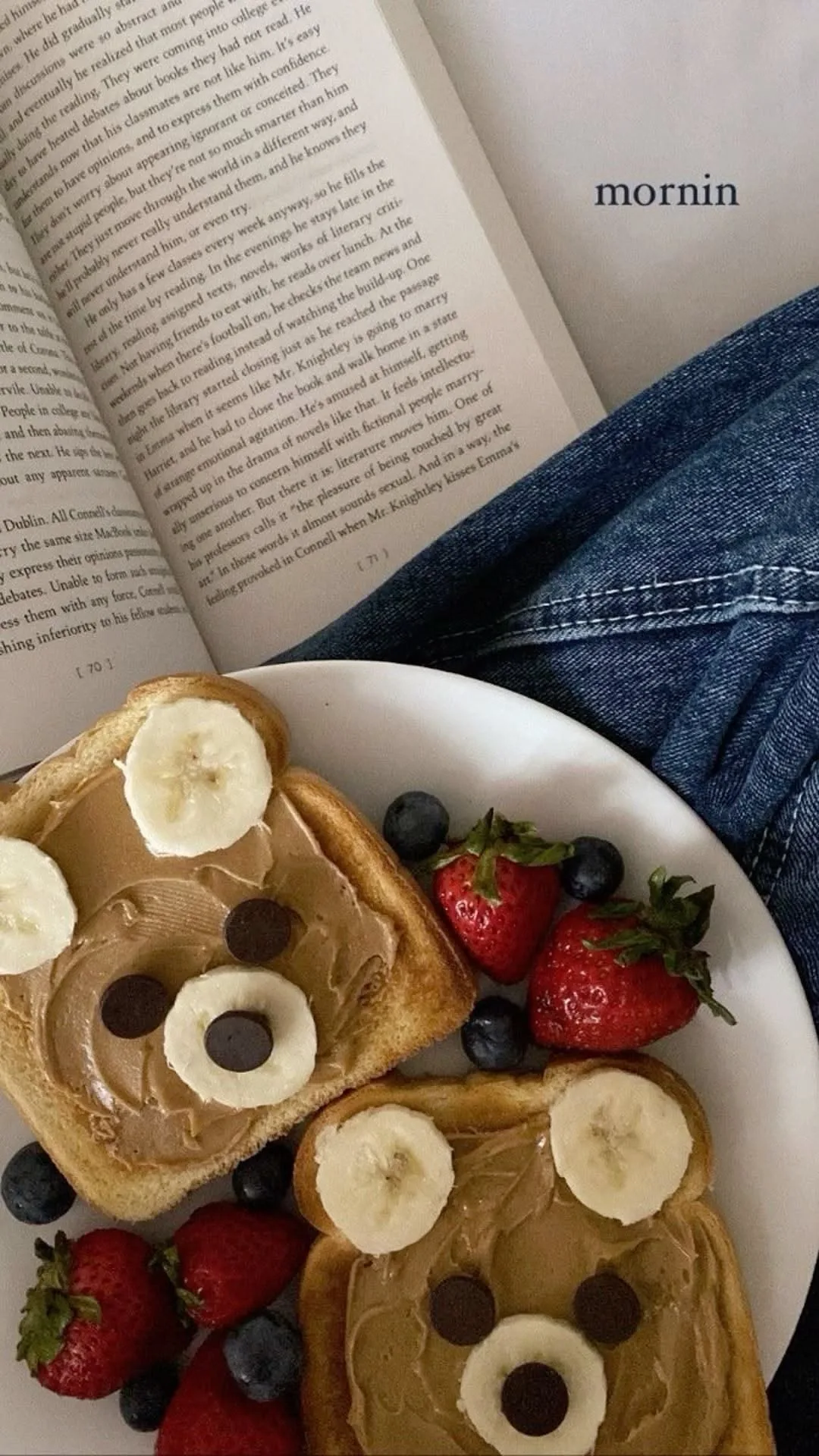 Zwei Toastscheiben mit Erdnussbutter, Bananen und Schokodrops als Bärengesichter dekoriert auf einem weißen Teller.